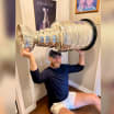 Sam Bennett poses with Stanley Cup in front of childhood poster